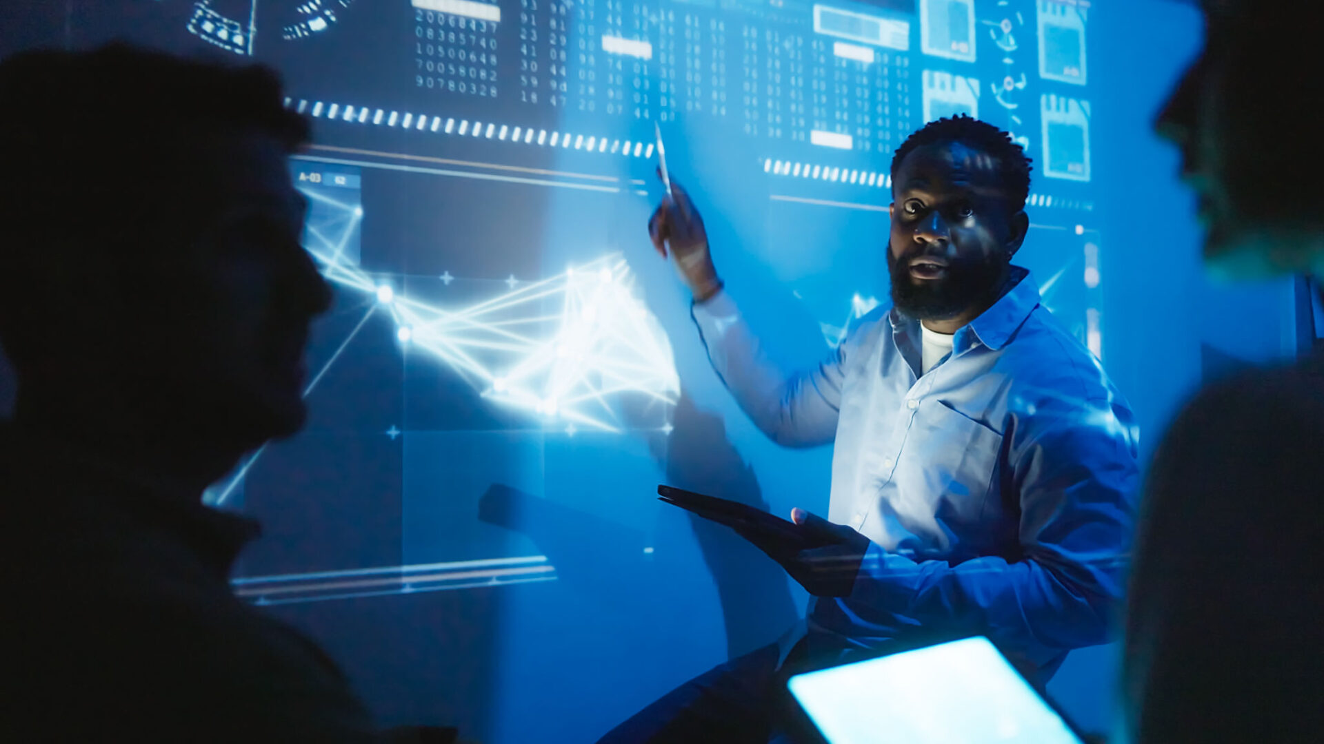 Man presenting data on digital screen.